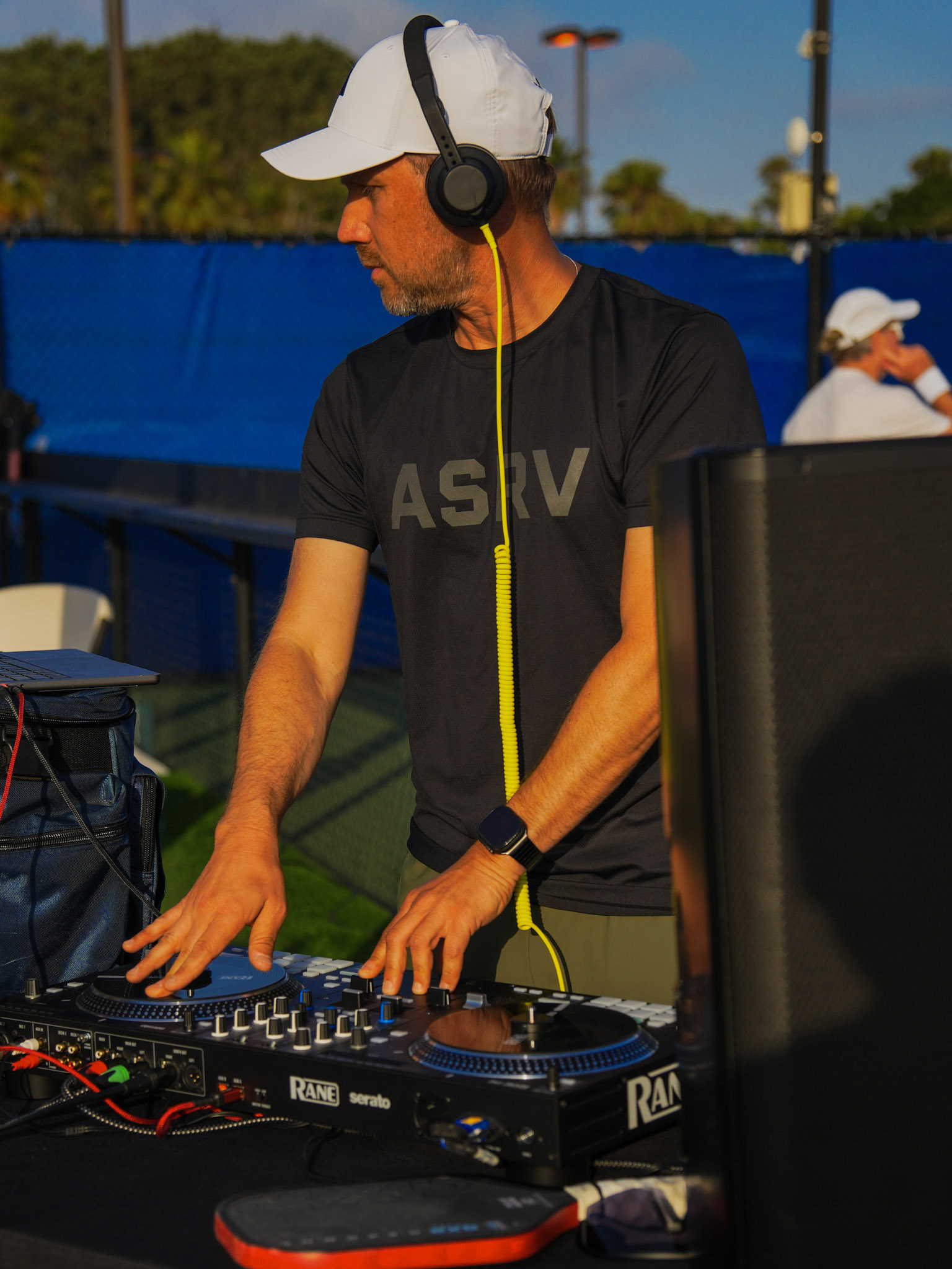 DJ playing music courtside at a pickleball social event