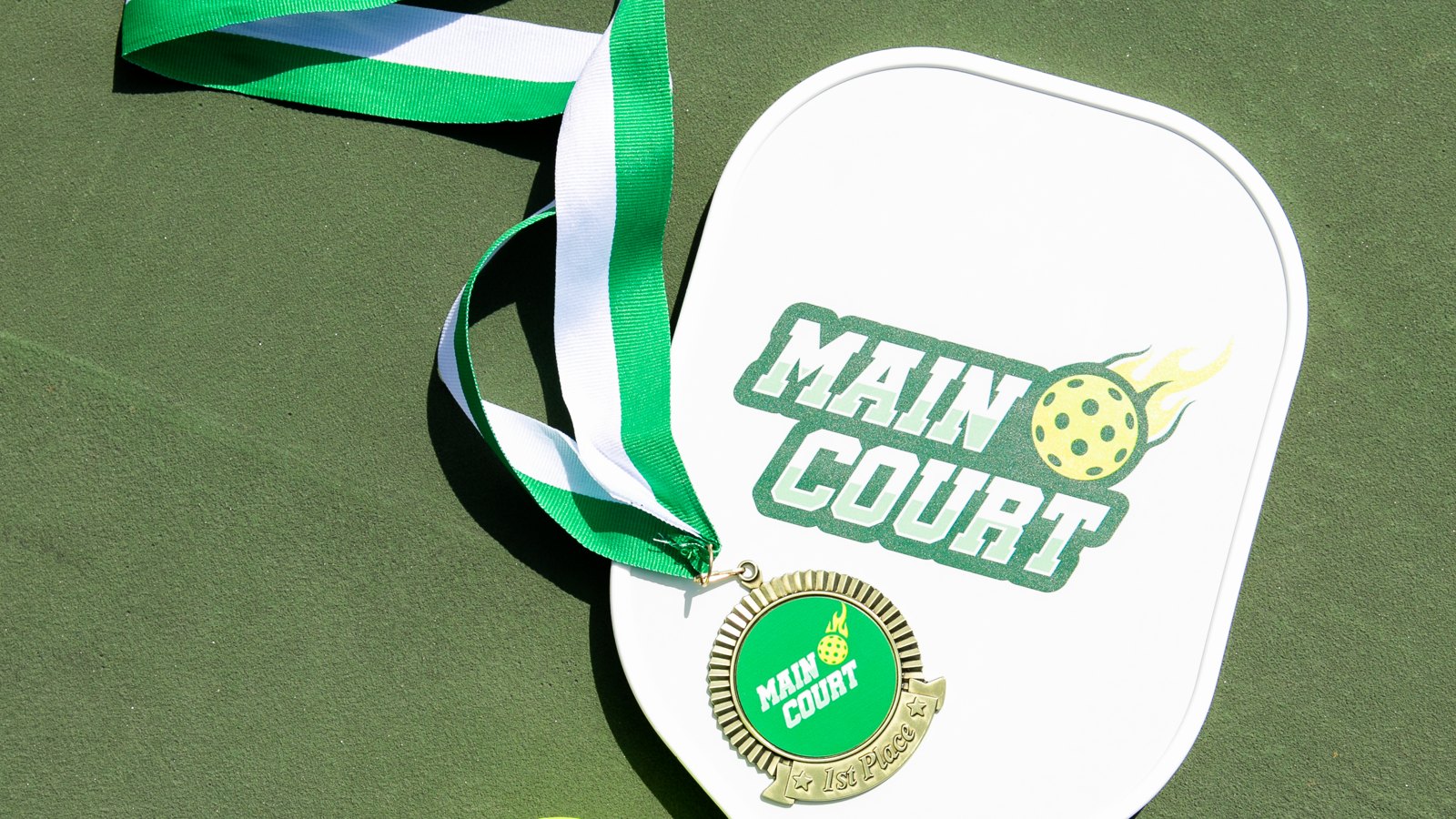 Main Court pickleball paddle and first-place medal on a court - free pickleball round robin app